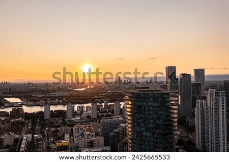 Panoramic aerial skyline view of east London at sunrise with skyscrapers of Canary Wharf and beautiful colorful sky at background
