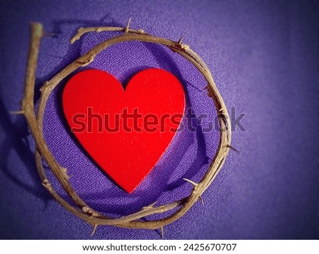 Lent Season, Holy Week, Ash Wednesday, Palm Sunday and Good Friday concepts. Close up crown of thorns with red heart shaped in purple background. Stock photo.