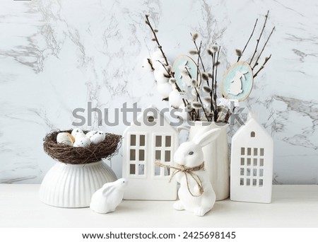 Easter composition on a light background. Cute white rabbits, willow twigs, Easter eggs symbol of the Easter holiday. Home and office decoration. The bright holiday of Easter.

