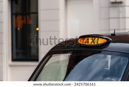 Taxi with it's sign on ready for hire Royalty-Free Stock Photo #2425706161