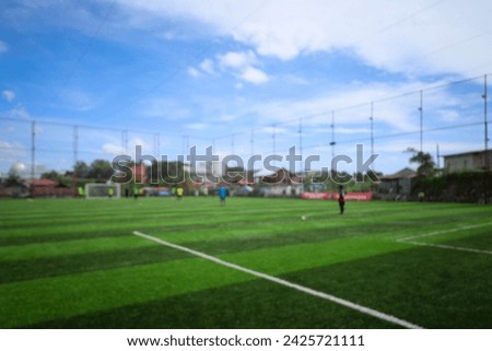 Blurred picture of soccer field at school on summer day time. Background image of blurred football pitch. Image for background usage