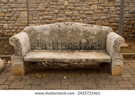 An old stone outdoor bench in the shape of a double sofa in Premantura in Medulin municipality, Istria, north west Croatia Royalty-Free Stock Photo #2425721461