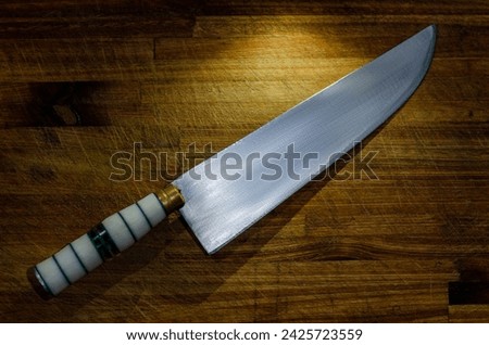 Professional kitchen knife on a wood rusty table background