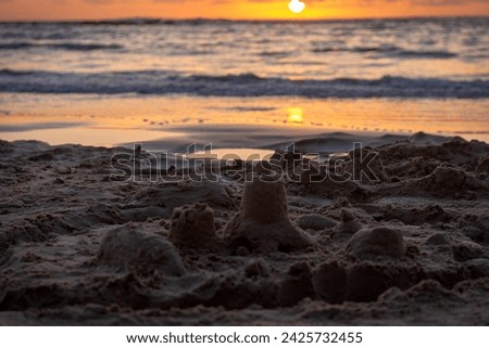 

Beautiful spring sunset on the Mediterranean Sea. In the foreground is a blurry sand castle. Selective focus. Israel