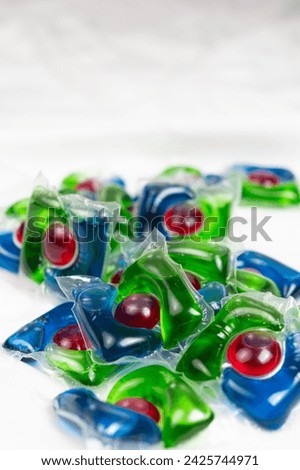 Lots of laundry pods on satin fabric close-up.
