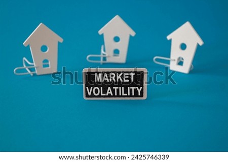 Market volatility symbol. Concept words Market volatility on black blackboard near miniature houses. Beautiful blue background. Business marketing concept. Copy space.