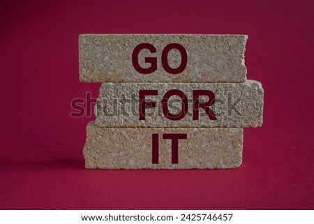 Go for it symbol. Concept words go for it on brick blocks. Beautiful red background. Business motivational concept, copy space.