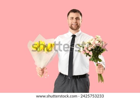 Handsome man with flowers on pink background