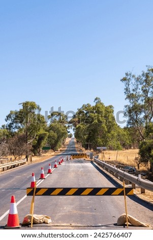 Roadworks lane closure, barrier sign and witches hats on a bridge on a remote Australian Highway. 