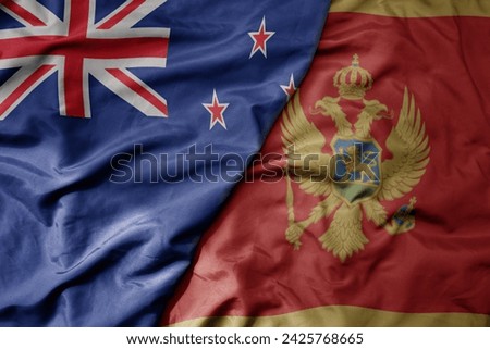 big waving national colorful flag of montenegro and national flag of new zealand . macro
