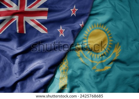 big waving national colorful flag of kazakhstan and national flag of new zealand . macro