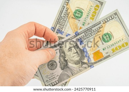 Hand holding money isolated on white background. One hundred Dollars bill on man hand to paying and giving. Business and Finances concept. 100 Dollars Cash Money. Hands with money American dollars.