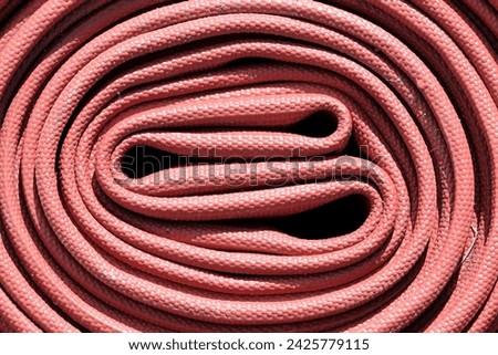 The 2.5 inch fire hose is red. A hose that firefighters often carry when carrying out their duties.