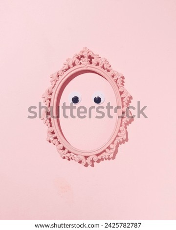 A pair of eyes inside an oval vintage picture frame, minimalistic portrait concept, pastel pink background.