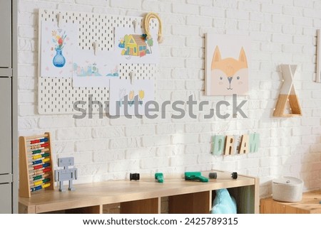 Interior of playroom with pegboard and pictures in kindergarten