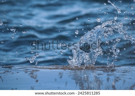 Splash in the water, water droplets, abstract blue background