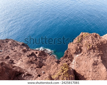 Hiking Montana Roja in El Médano, Tenerife. Red volcanic cliff with blue sea. View of the Atlantic