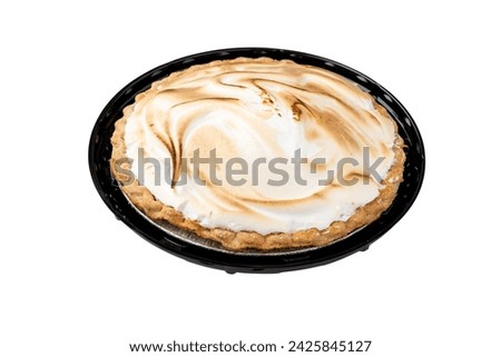 Lemon Meringue pie. Isolated low-angle in black plastic tray.