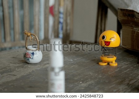 a spring emoticon doll and a cute ceramic jar on the table