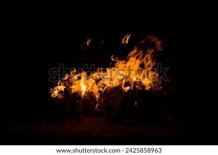 View of a log bonfire lit in the dark of night Royalty-Free Stock Photo #2425858963