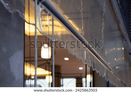 transparent plastic awning of outdoor shop. plastic rain cover of house. Royalty-Free Stock Photo #2425863503
