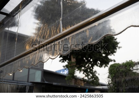 transparent plastic awning of outdoor shop. plastic rain cover of house. Royalty-Free Stock Photo #2425863505