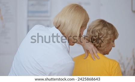 A physiatrist examines a patient with spinal cord compression, performing a physical examination Royalty-Free Stock Photo #2425868643