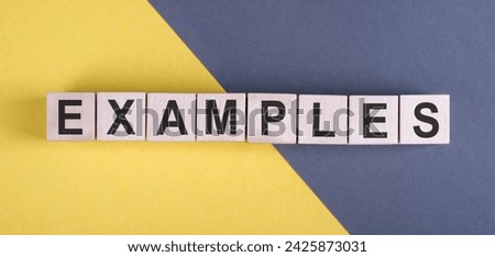 Examples word written on wood block. Examples text on yellow gray desk, concept.