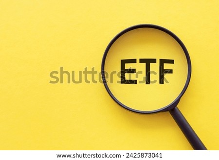 Exchange traded fund. Magnifying glass with ETF text. Analysis of economic recession and crisis, risks from shares purchase or sale. High quality photo