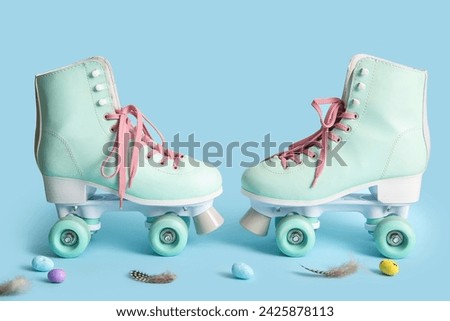 Vintage roller skates with Easter eggs and feathers on blue background