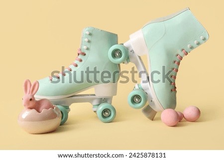 Vintage roller skates with Easter eggs and toy bunny on yellow background
