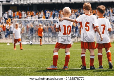 School Boys as Soccer Friends Teammates. Kids United in a Sports Team During Penalty Kick Game. Children in Football Uniforms at a Sports Arena Playing a Final Match. Young Players Supports Each Other Royalty-Free Stock Photo #2425878771