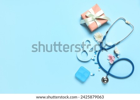 Composition with stethoscope, pills, flowers and gift for International Women's Day on color background Royalty-Free Stock Photo #2425879063