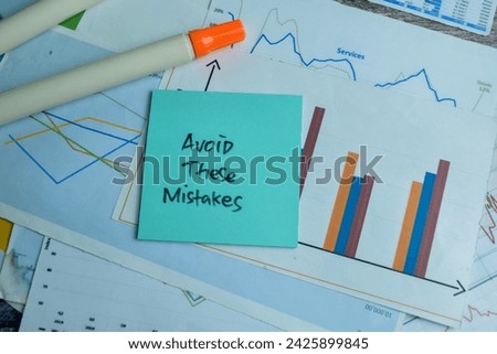 Concept of Avoid These Mistakes write on sticky notes isolated on Wooden Table.