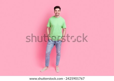Full length body photo of young handsome guy wearing green t shirt with jeans posing candid person isolated on pink color background