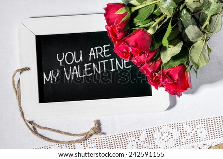 Image of a slate blackboard with message YOU ARE MY VALENTINE and red roses