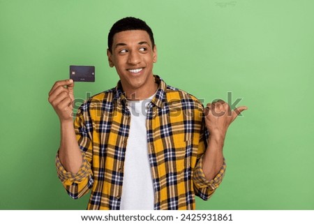 Photo of young guy begin his business pointing finger advert for debit card features opportunities isolated over green color background