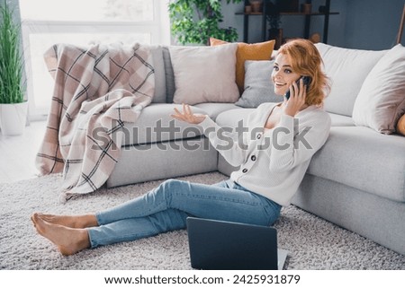 Full body photo of nice cheerful person sit barefoot comfy carpet floor chatting telephone laptop modern interior house indoors