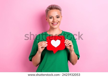 Photo of cute nice girl beaming smile arms hold paper like notification icon card isolated on pink color background