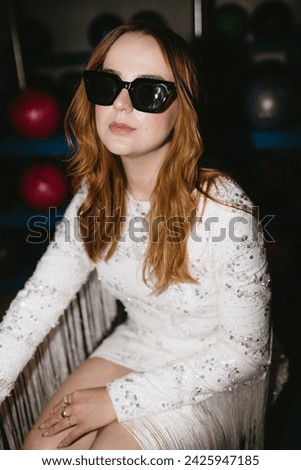 Cool girl in flashy dress and sunglasses at party
