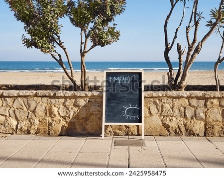 cafe menu board on the background of the sea beach and blue sky Royalty-Free Stock Photo #2425958475