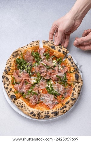 Pizza with prosciutto, arugula and parmesan