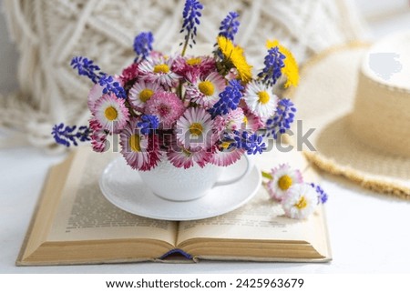 Flower arrangement with daisy and other summer flowers in a white cup. Spring floral composition. Greeting postcard for Mother's or Women's day, birthday, anniversary. Cozy atmosphere