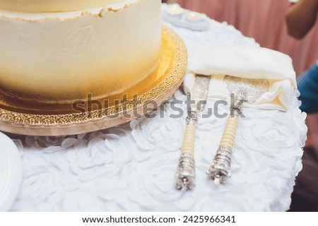 Three-tiered white wedding cake decorated with flowers from mastic on a white wooden table. Picture for a menu or a confectionery catalog with copy space