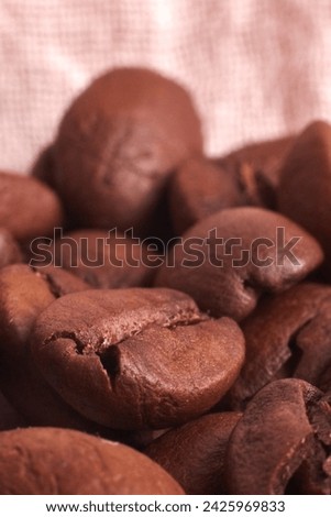 Coffee beans on a texture background. Fragrant, roasted Arabica beans. Macro photography. Light brown background with burlap texture