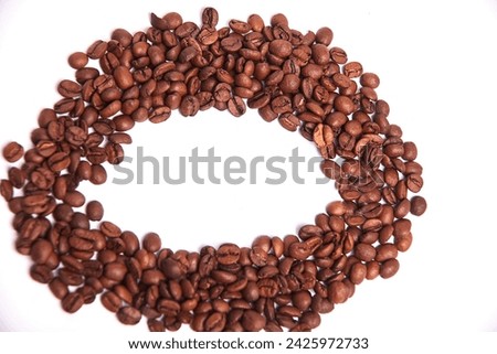 Coffee beans on a white background in the shape of an oval. Fragrant, roasted Arabica beans. Copy space