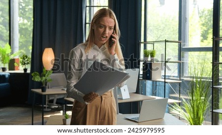 Stressed Caucasian businesswoman talk mobile phone in office dissatisfied with business documents problem conflict furious mad angry woman director boss employer quarrel throwing papers finish call Royalty-Free Stock Photo #2425979595