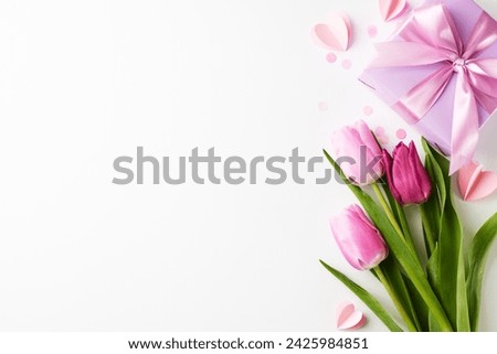 Serenade of petals: curating the quintessence of appreciation. Top view of gift box, bouquet of fresh tulips and tender paper hearts on white background with space for sophisticated marketing content