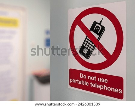 A warning sign asking for people to not use portable or mobile  phones