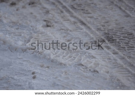 Tire tracks imprinted in snow Royalty-Free Stock Photo #2426002299